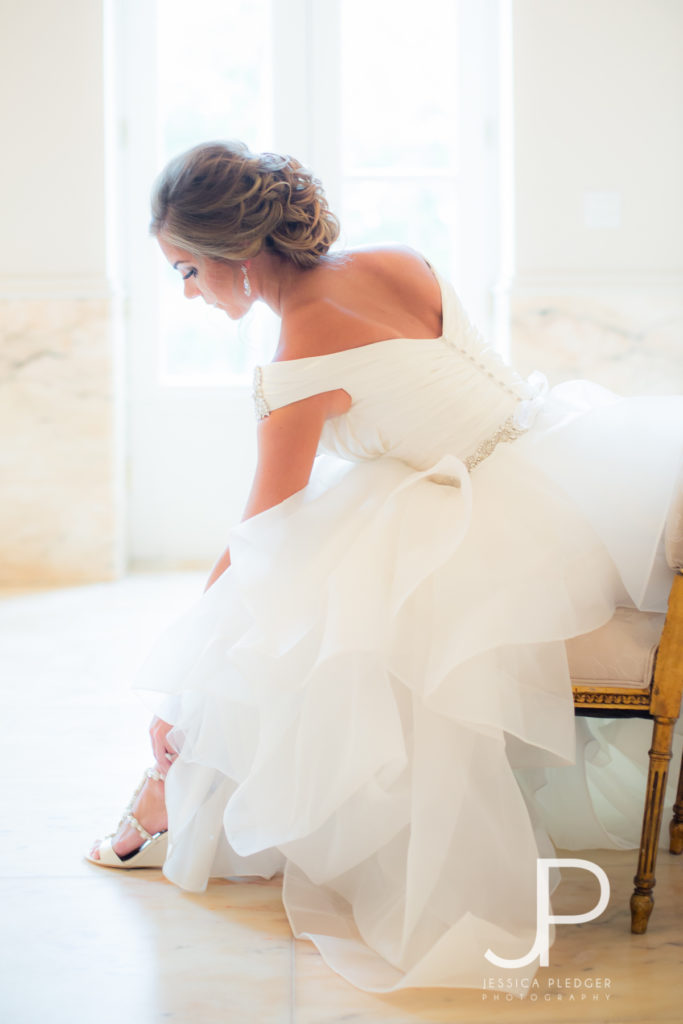 Bride putting on shoes at Chateau Cocomar