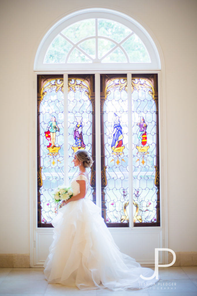 Bride in front of stained glass at Chateau Cocomar